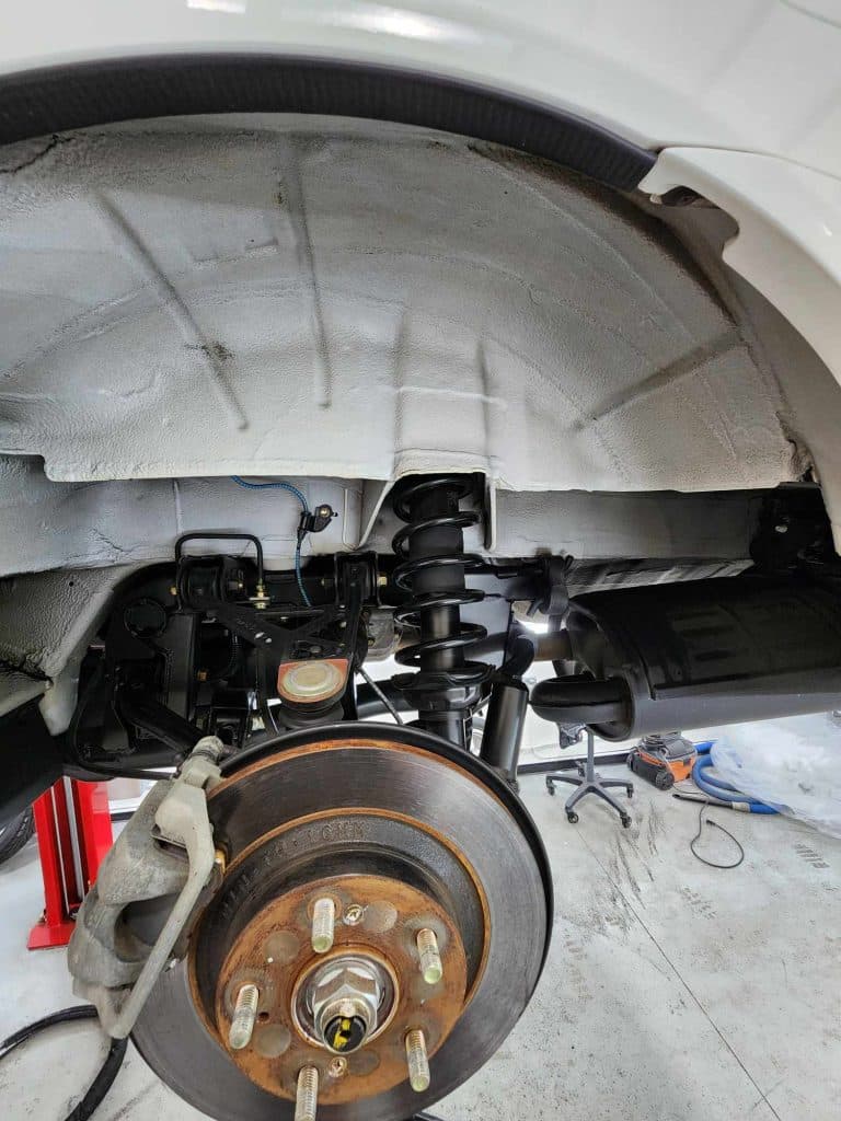 Car wheel and suspension system close-up view.